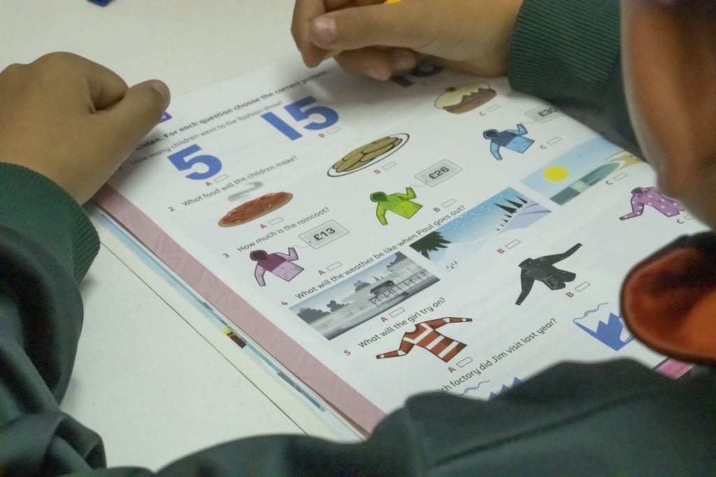 Alumno trabajando con un libro de actividades de inglés